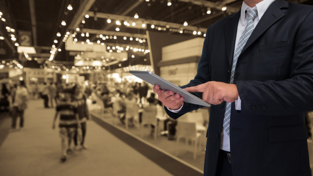 businessman using tablet with blurred event background